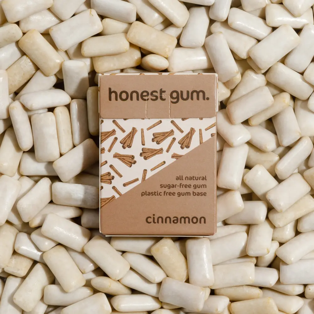 obrázek žvýkačky skořicové přírodní žvýkačky od honest gum ve flipové krabičce zepředu na pozadí se žvýkačkami | Žvýkačky bez plastu, bez cukru, udržitelné a bez aspartamu | Pro web: healthychewinggum.com | Zdroj: honest gum