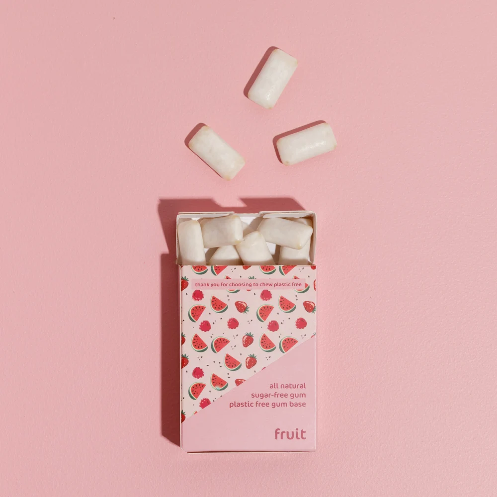 picture of Fruit All Nature Chewing Gum from honest gum spilled out of the flip box from the front with 12 pcs on a pink white background with a box shadow | Plastic free, sugar free, sustainable and aspartam free | For website: healthychewinggum.com | Source: honest gum