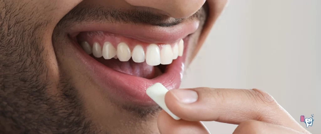 The picture shows a man with a thin beard smiling with white teeth while putting a chewing gum in his mouth | For article: Teeth Whitening With Chewing Gum | For website: healthychewinggum.com | Source: shutterstock