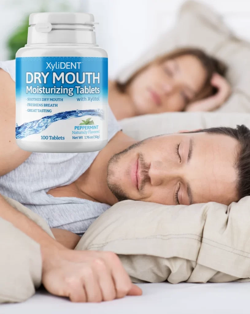 A young couple sleeping peacefully and lying in bed on pillows covered with a duvet in a bright bedroom already in daylight, a man in the foreground in detail and a woman in the background on a blurred background | Banner for the products Healthy moisturizing pastilles for dry mouth | For the website: healthychewinggum.cz (Healthy chewing gum) | Photo source: shutterstock.com