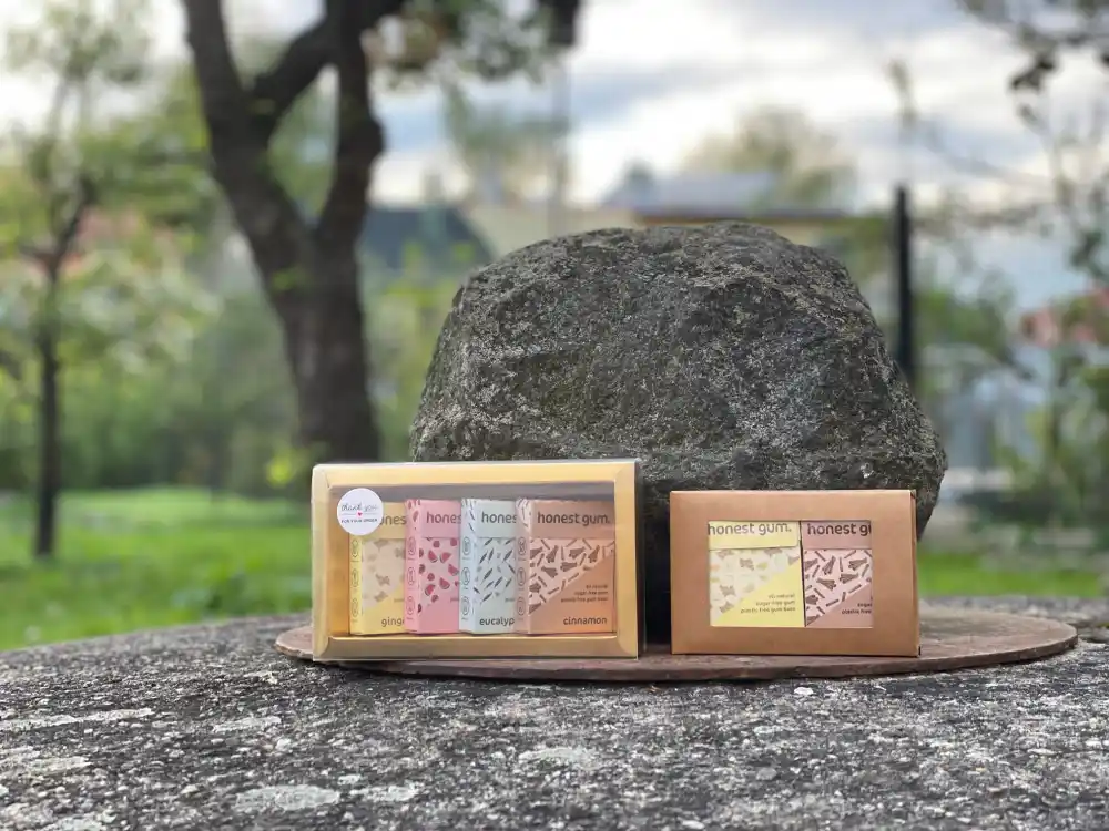 Australské žvýkačky Honest Gum (menší i větší balení) na studni v zahradě v pozadí strom a kámen zabalené v hnědém obalu s černou i bílou samolepkou s textem "for you" a "thank you" | Autor: Jiří Samuel | Pro web: healthychewinggum.cz (zdravezvykacky.cz) | Pro článek: Pozvánka na výstavy