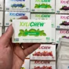 Xylichew spearmint chewing gum in a blister holding in the left hand in the background with other blisters with other flavours