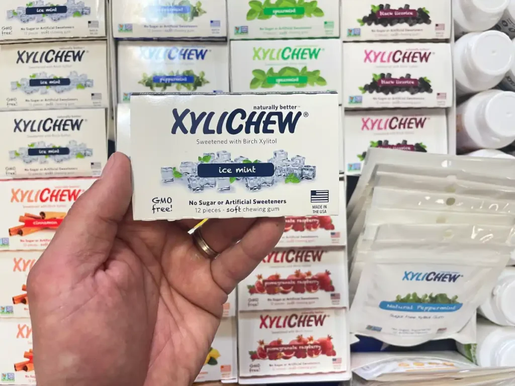 Xylichew ice mint chewing gum in a blister holding in the left hand in the background with other blisters with other flavours