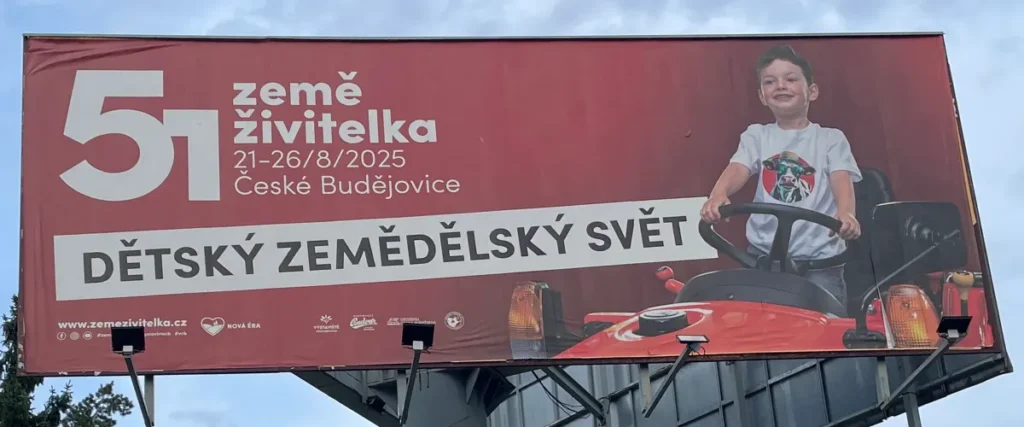 Fotografie bilboardu dítěte sedící na trakotru s popisem Dětský zemědělský svět a popisem výstavy : 51. země živitelka 21-26/8/2025 České Budějovice, výstavy Země živitelka 2025 v Českých Budějovicích | Pro: Pozvánka na výstavu Země živitelka 2025 na výstaviště České Budějovice | Autor fotografie a úprav: Jiří Samuel | Pro web: healthychewinggum.com
