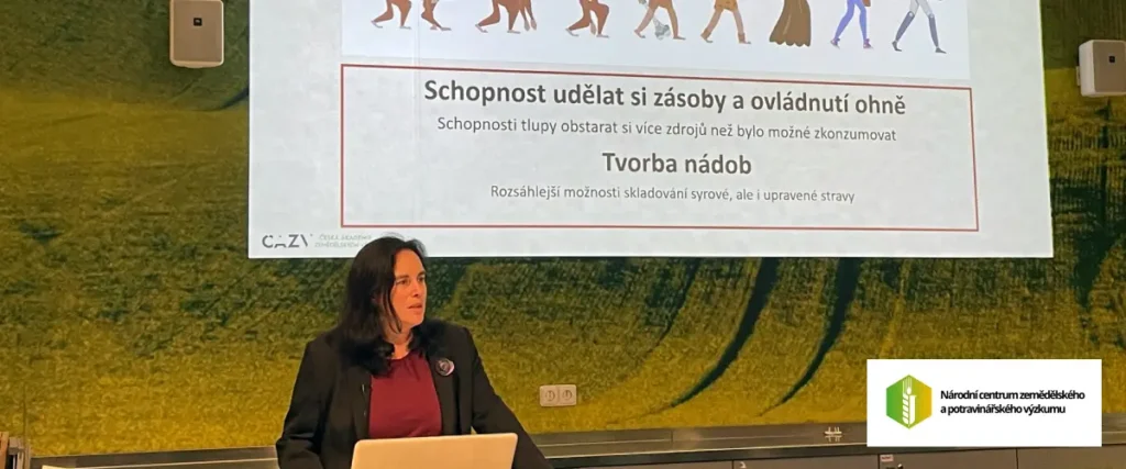 Foto mit Frau Dr. Ing. Eliška Kováříková, Ph.D., vom Nationalen Zentrum für Landwirtschafts- und Lebensmittelforschung, v.v.i., vor dem Hintergrund einer Leinwand mit Erläuterungen zum Tag der offenen Tür | Fotoautor: Jiří Samuel | Foto mit Genehmigung von Frau Kováříková verwendet | Eigentum des Fotos: Jiří Samuel für healthychewinggum.com