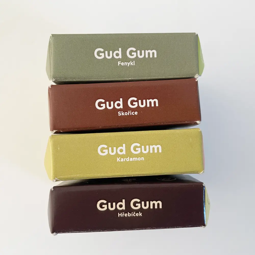 Přírodní žvýkačky Gud Gum - 4 příchutě s kořením - Fenyklové, Skořicové, Kardamon a Hřebíčkové na bílém pozadí | Přírodní žvýkačky bez plastových materiálů (s přírodní gumovou bází chicle), bez škodlivé chemie | Viditelné jen horní hrana krabice žvýkaček